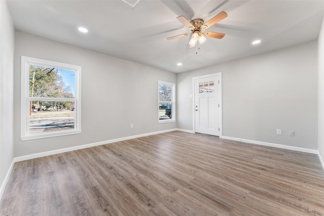 spare room with hardwood / wood-style flooring, a healthy amount of sunlight, and ceiling fan