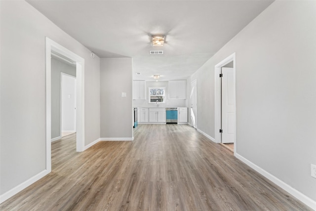 unfurnished living room with sink and light hardwood / wood-style flooring