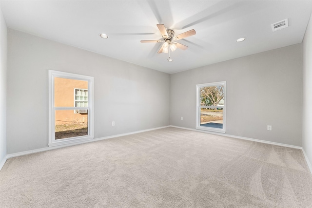 empty room featuring ceiling fan, plenty of natural light, and carpet floors