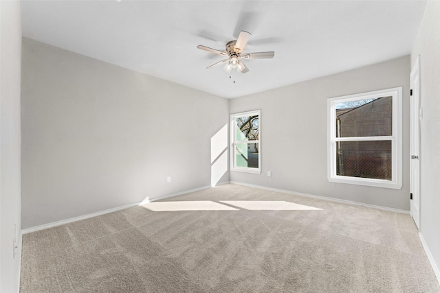 carpeted spare room featuring ceiling fan