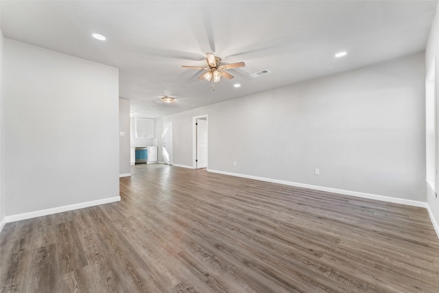 unfurnished living room with dark wood-type flooring and ceiling fan