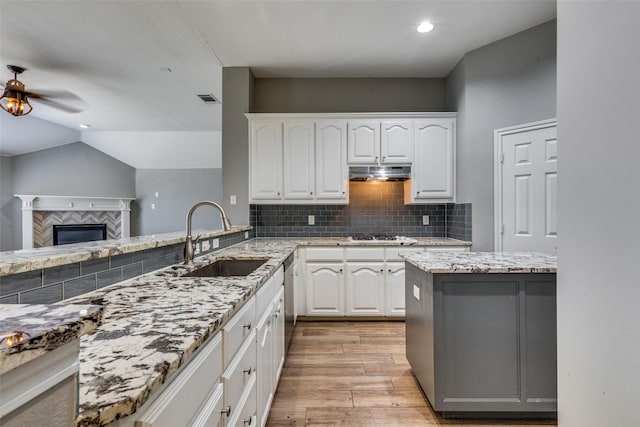 kitchen featuring backsplash, sink, light hardwood / wood-style flooring, and white cabinets