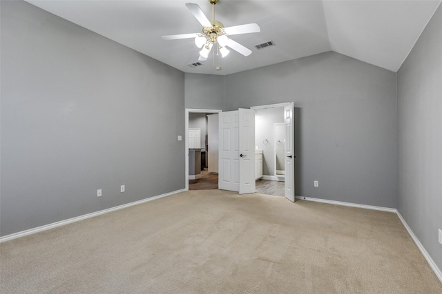 unfurnished bedroom featuring connected bathroom, vaulted ceiling, light colored carpet, and ceiling fan