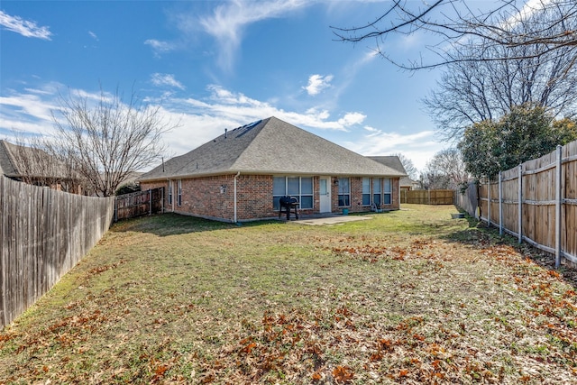 rear view of property featuring a lawn and a patio