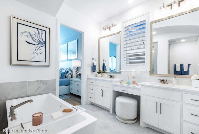 bathroom with vanity and a tub