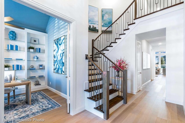 staircase with a high ceiling and wood-type flooring