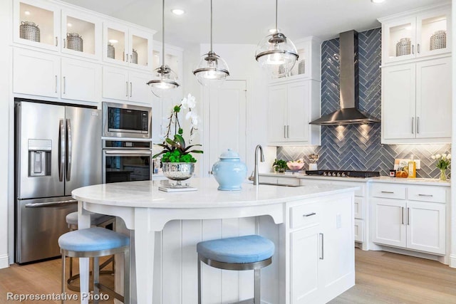 kitchen with sink, stainless steel appliances, white cabinets, and wall chimney exhaust hood