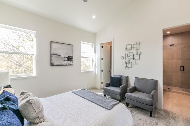 tiled bedroom featuring lofted ceiling and connected bathroom