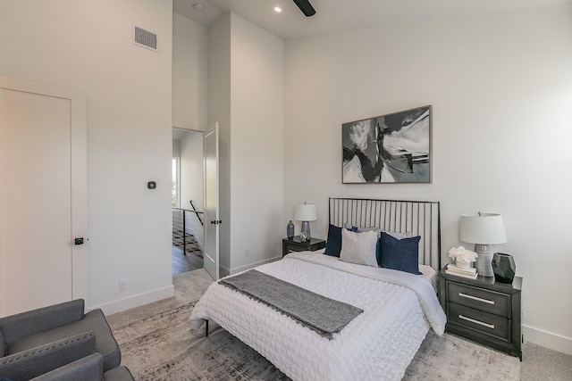 bedroom with light carpet and a high ceiling