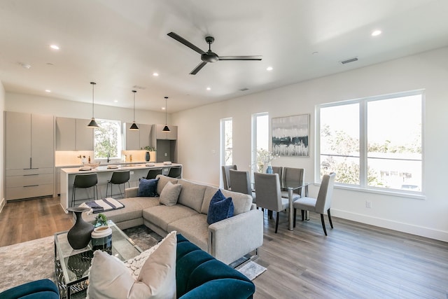 living room featuring light hardwood / wood-style flooring and ceiling fan