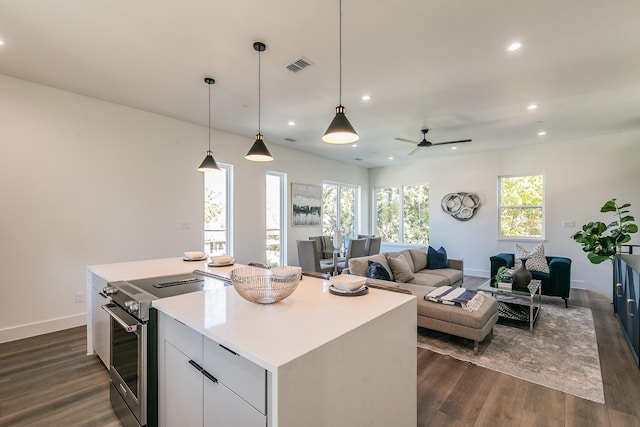 kitchen featuring pendant lighting, dark hardwood / wood-style floors, a kitchen island, electric stove, and white cabinets