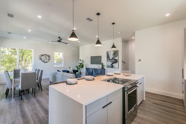 kitchen with pendant lighting, stainless steel electric range, white cabinetry, a center island, and dark hardwood / wood-style flooring