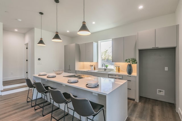 kitchen featuring a kitchen island, gray cabinetry, pendant lighting, and dark wood-type flooring