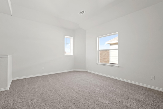 empty room with baseboards, carpet floors, visible vents, and a healthy amount of sunlight