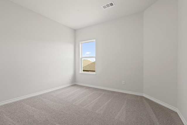 spare room with carpet, visible vents, and baseboards