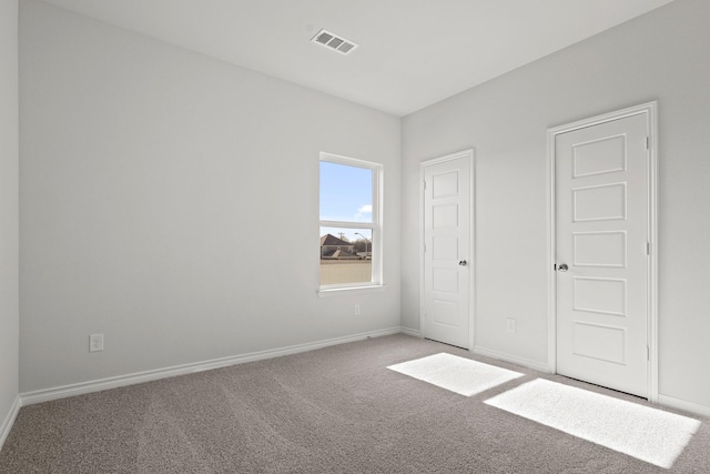 unfurnished bedroom featuring baseboards, visible vents, and carpet flooring