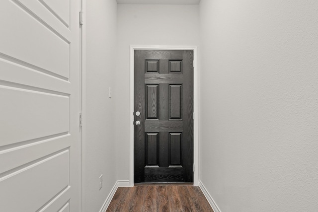 entryway featuring dark wood finished floors and baseboards