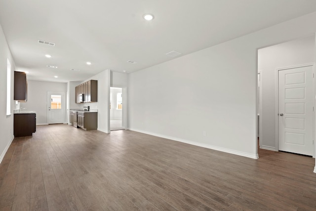 unfurnished living room with dark wood-type flooring, recessed lighting, visible vents, and baseboards