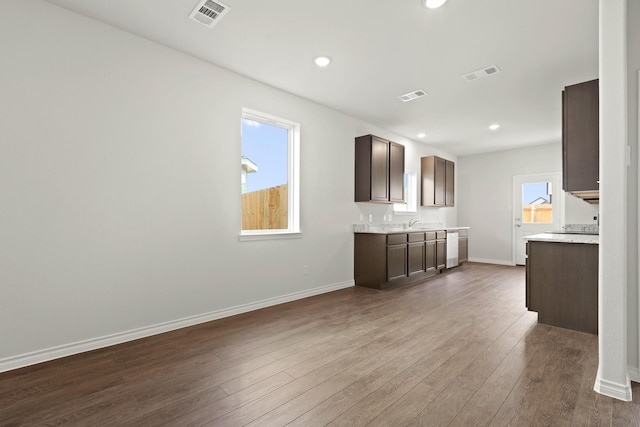 kitchen with dark hardwood / wood-style flooring, sink, and dark brown cabinets