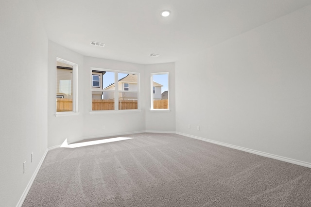 spare room with carpet floors, visible vents, baseboards, and recessed lighting