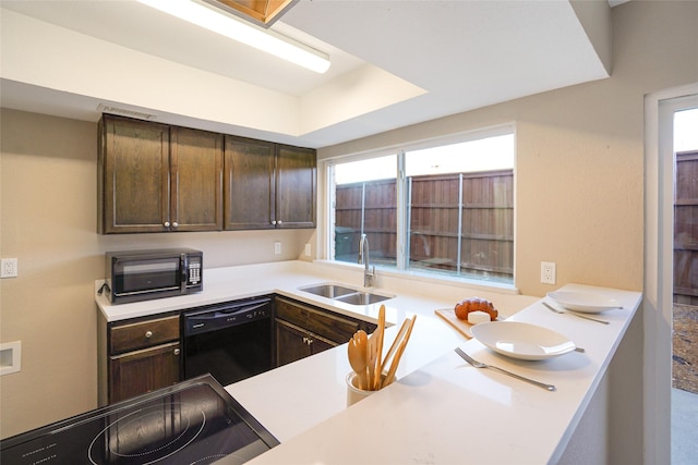 kitchen featuring sink, a tray ceiling, dark brown cabinets, and black appliances