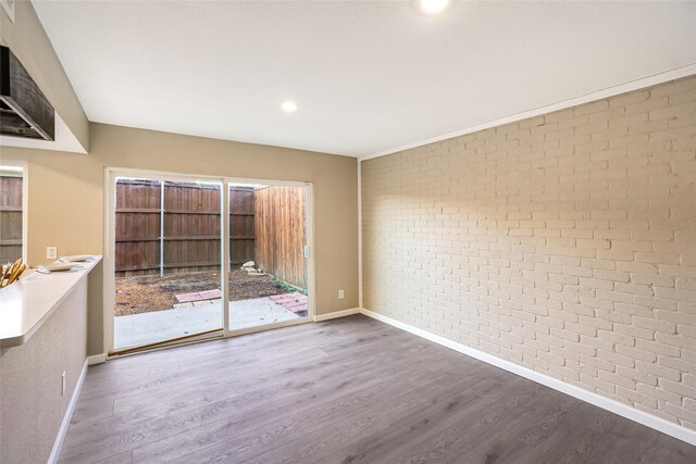 2658 Via Valencia, Carrollton, TX 75006 - empty room featuring brick wall, baseboards, wood finished floors, and recessed lighting