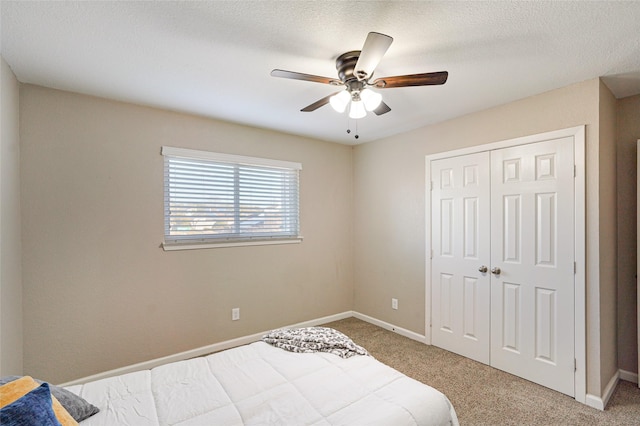 bedroom featuring carpet, a textured ceiling, ceiling fan, and a closet