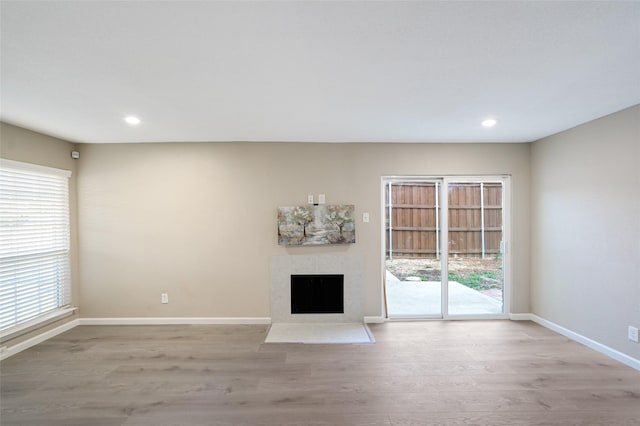 unfurnished living room featuring a fireplace and light hardwood / wood-style flooring