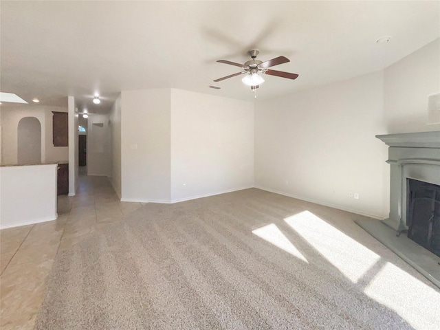 unfurnished living room with ceiling fan and light colored carpet