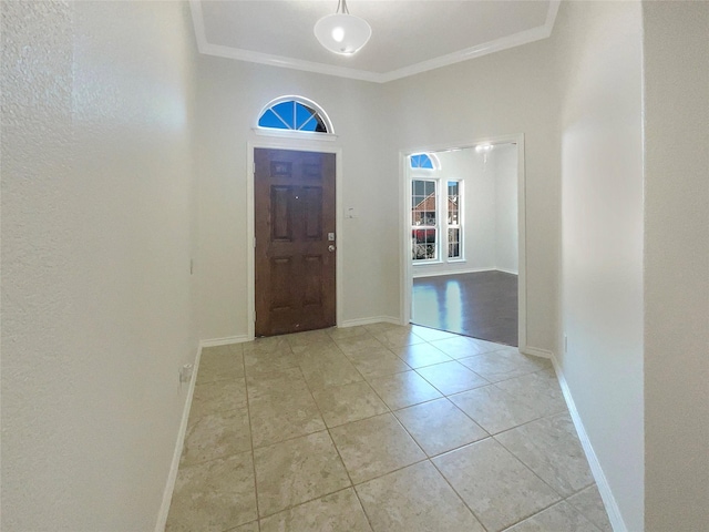 tiled foyer featuring crown molding and plenty of natural light