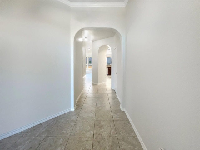 hall featuring ornamental molding and light tile patterned floors