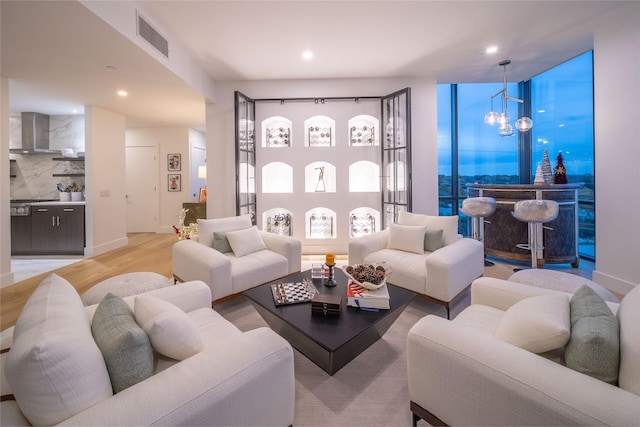 living area featuring a notable chandelier, visible vents, recessed lighting, and light wood-style floors