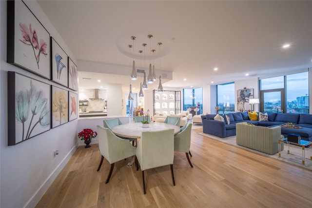 dining room featuring floor to ceiling windows, recessed lighting, light wood-style flooring, and baseboards