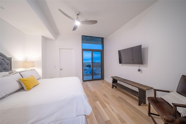 bedroom featuring light wood finished floors, baseboards, and a ceiling fan