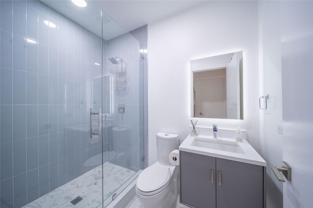 full bathroom with toilet, tiled shower, and vanity