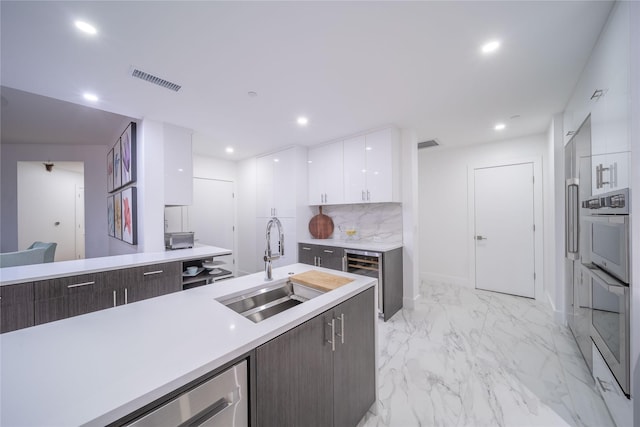 kitchen with white cabinetry, light countertops, modern cabinets, and a sink