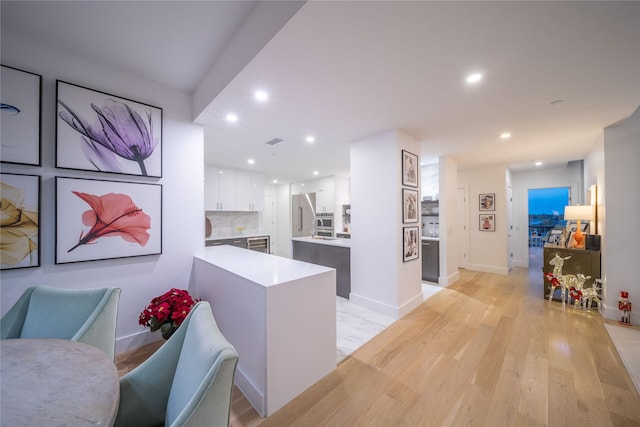 hallway featuring recessed lighting, light wood-type flooring, baseboards, and visible vents