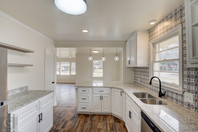 kitchen featuring white cabinetry, sink, decorative light fixtures, and light stone counters