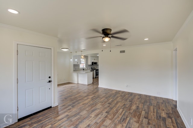 unfurnished living room with ornamental molding, dark wood-type flooring, sink, and ceiling fan