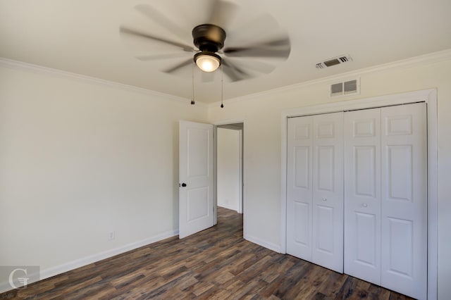 unfurnished bedroom featuring crown molding, ceiling fan, dark hardwood / wood-style floors, and a closet