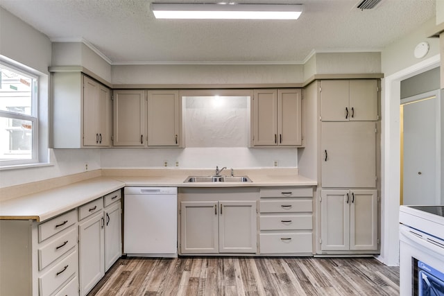 kitchen featuring white appliances, wood finished floors, light countertops, a textured ceiling, and a sink