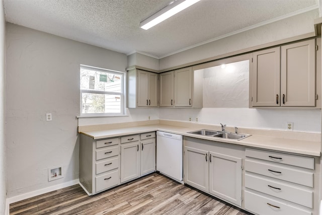 kitchen with dishwasher, light countertops, a textured ceiling, light wood-type flooring, and a sink