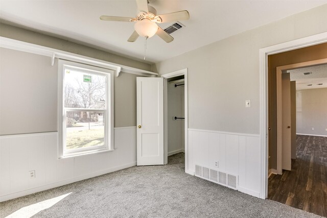 bedroom with light colored carpet, wainscoting, and multiple windows