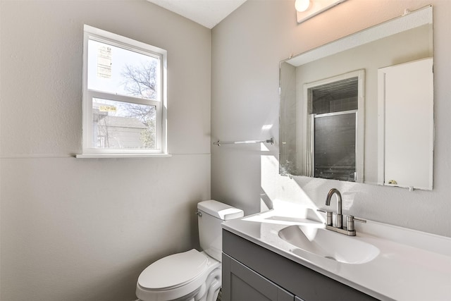 full bathroom featuring a stall shower, vanity, and toilet