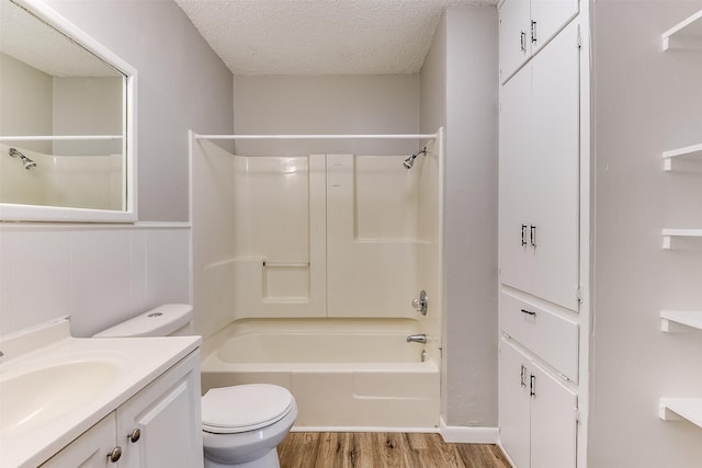 full bathroom featuring shower / bathing tub combination, toilet, a textured ceiling, vanity, and wood finished floors