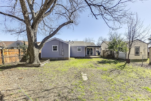 back of house featuring a fenced backyard and a yard