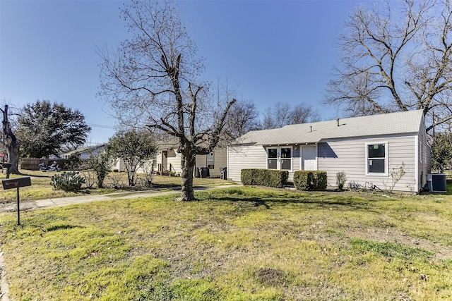 view of front of house featuring a front yard and central AC