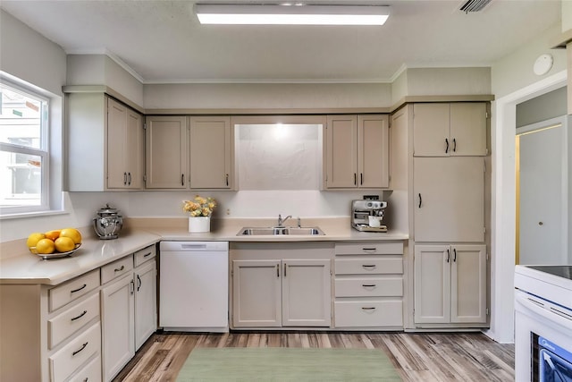 kitchen with white appliances, a sink, visible vents, light wood-style floors, and light countertops