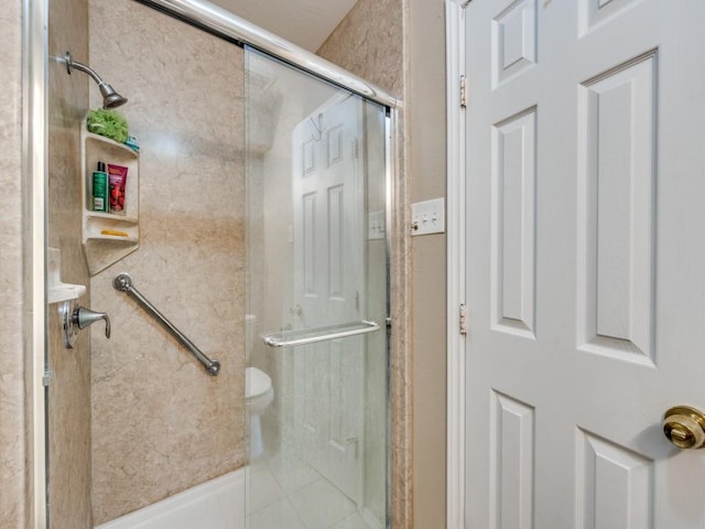 bathroom featuring toilet, tile patterned flooring, and a shower with door