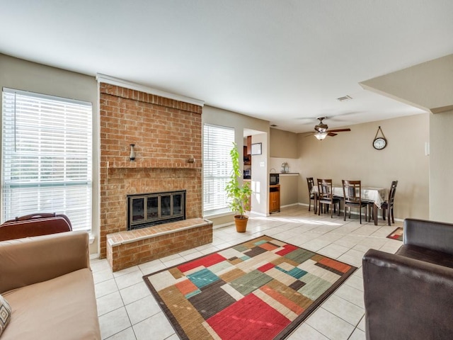 tiled living room featuring a fireplace and ceiling fan